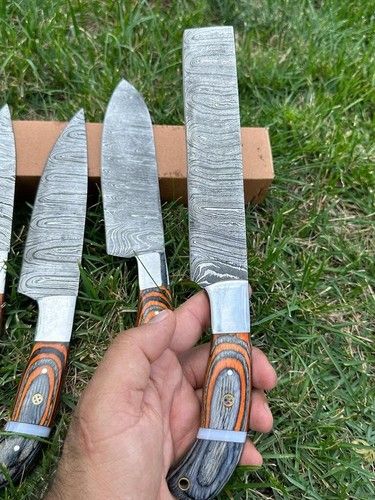 Professional Damascus chef knife set displayed on a wooden cutting board for culinary preparation.