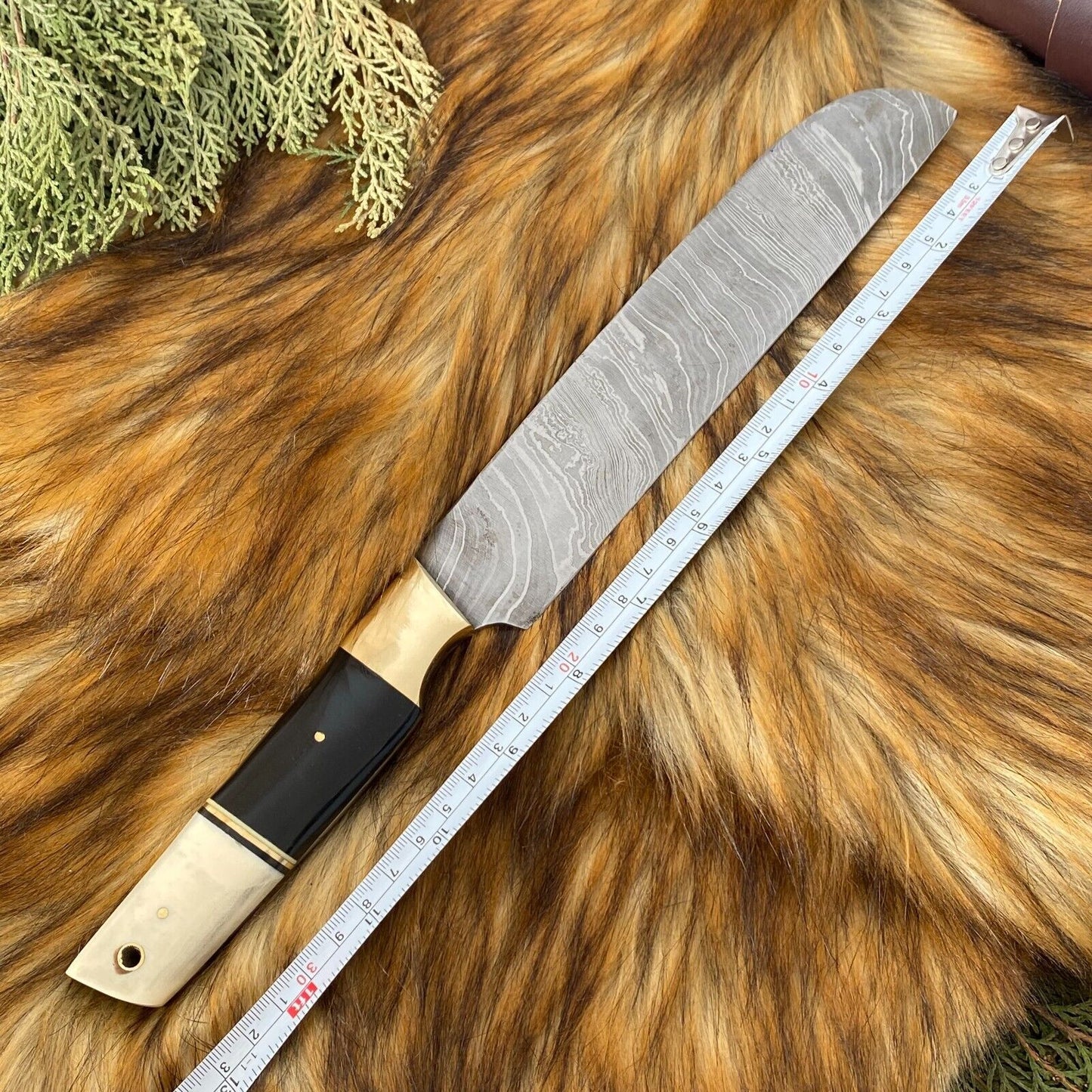 Detailed view of custom kitchen knife with sleek black coated steel blade and artisanal bone and horn handle.