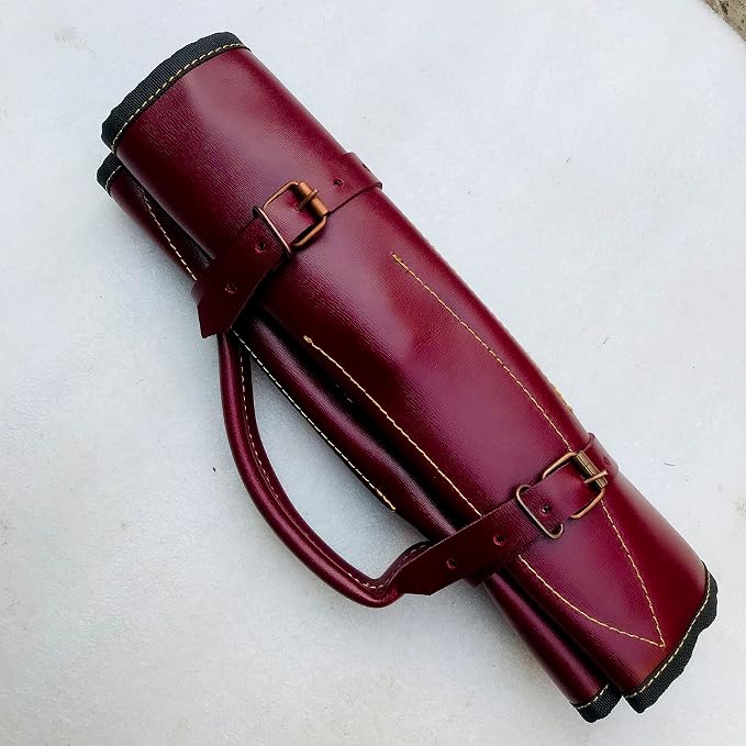 Burgundy leather knife roll rolled shut with a carry handle and brass buckles