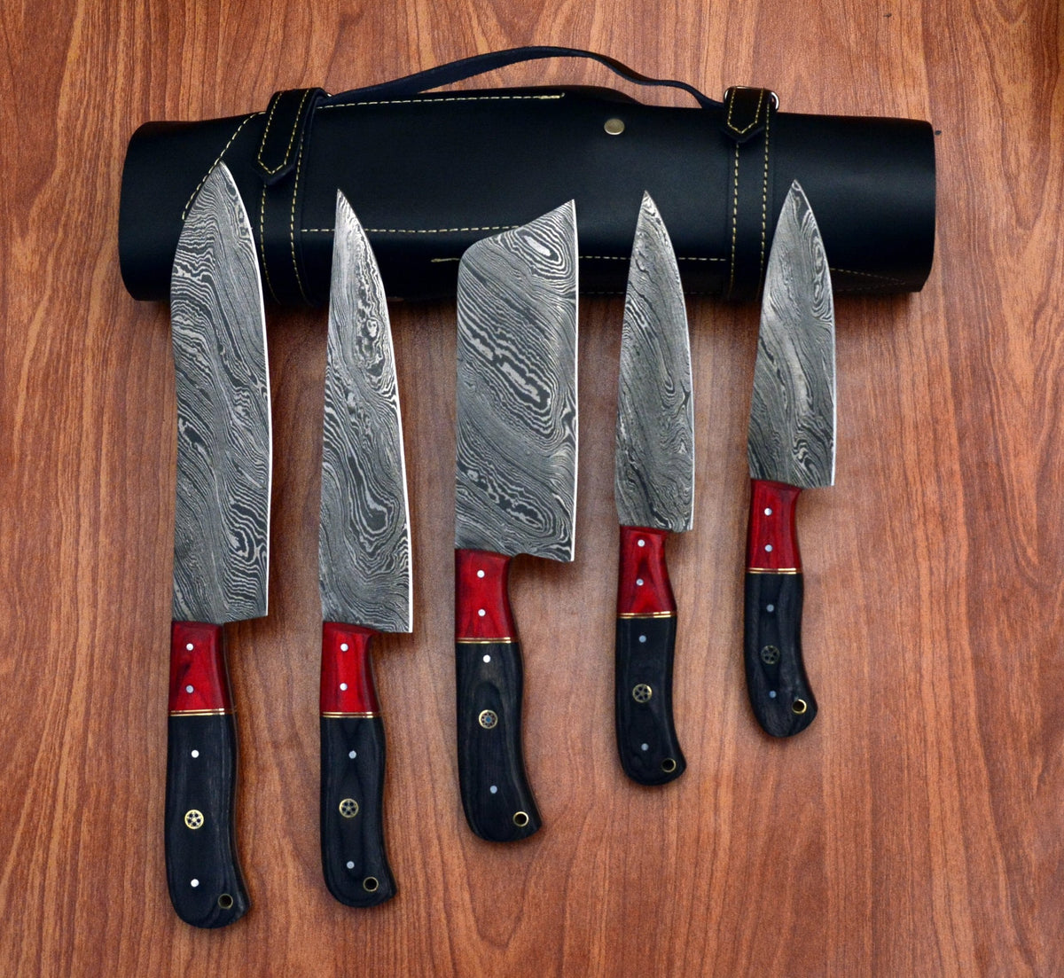 Damascus chef knife set fanned out beside black leather roll case