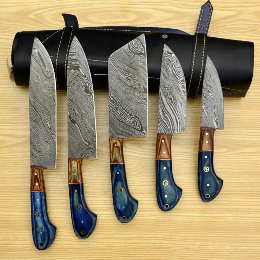 Damascus chef knife set with blue pakka wood handles in a row on wood table