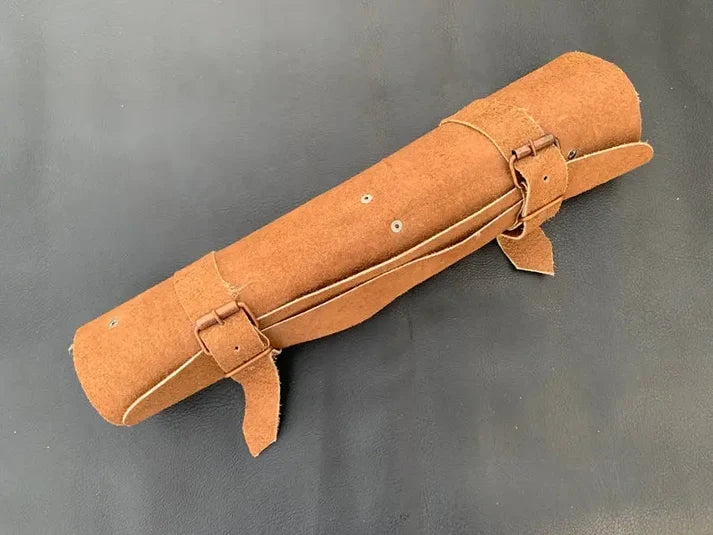 Tan suede knife roll rolled shut with two leather straps and metal buckles