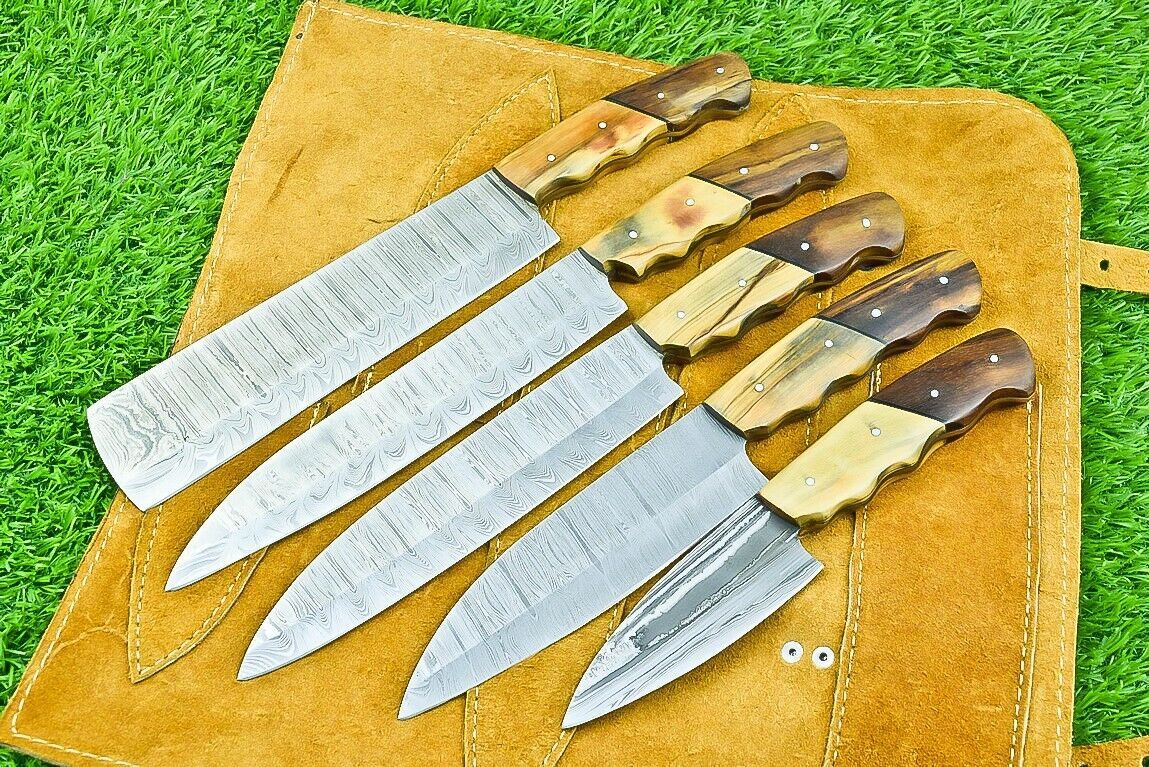 Professional Damascus kitchen knife with olive wood handle ready for culinary prep on a natural wooden cutting board.