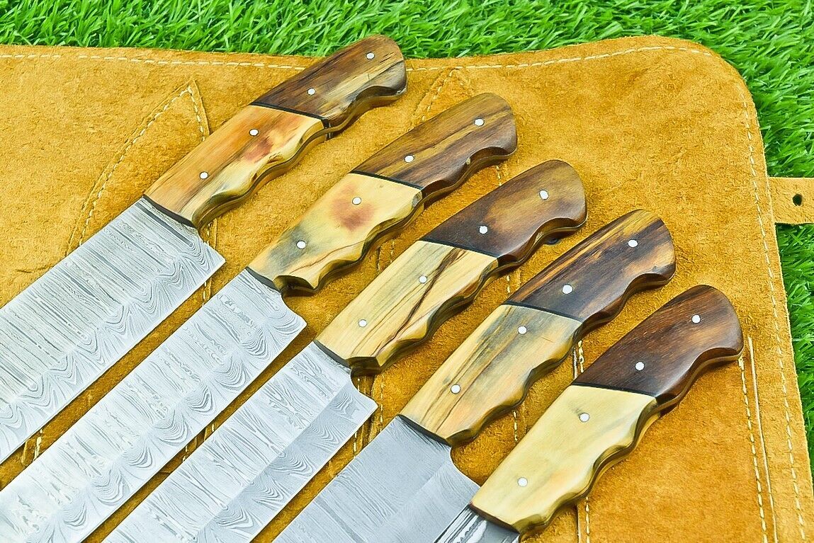 Close up of authentic olive wood handle and brass pins on a custom forged Damascus chef knife.