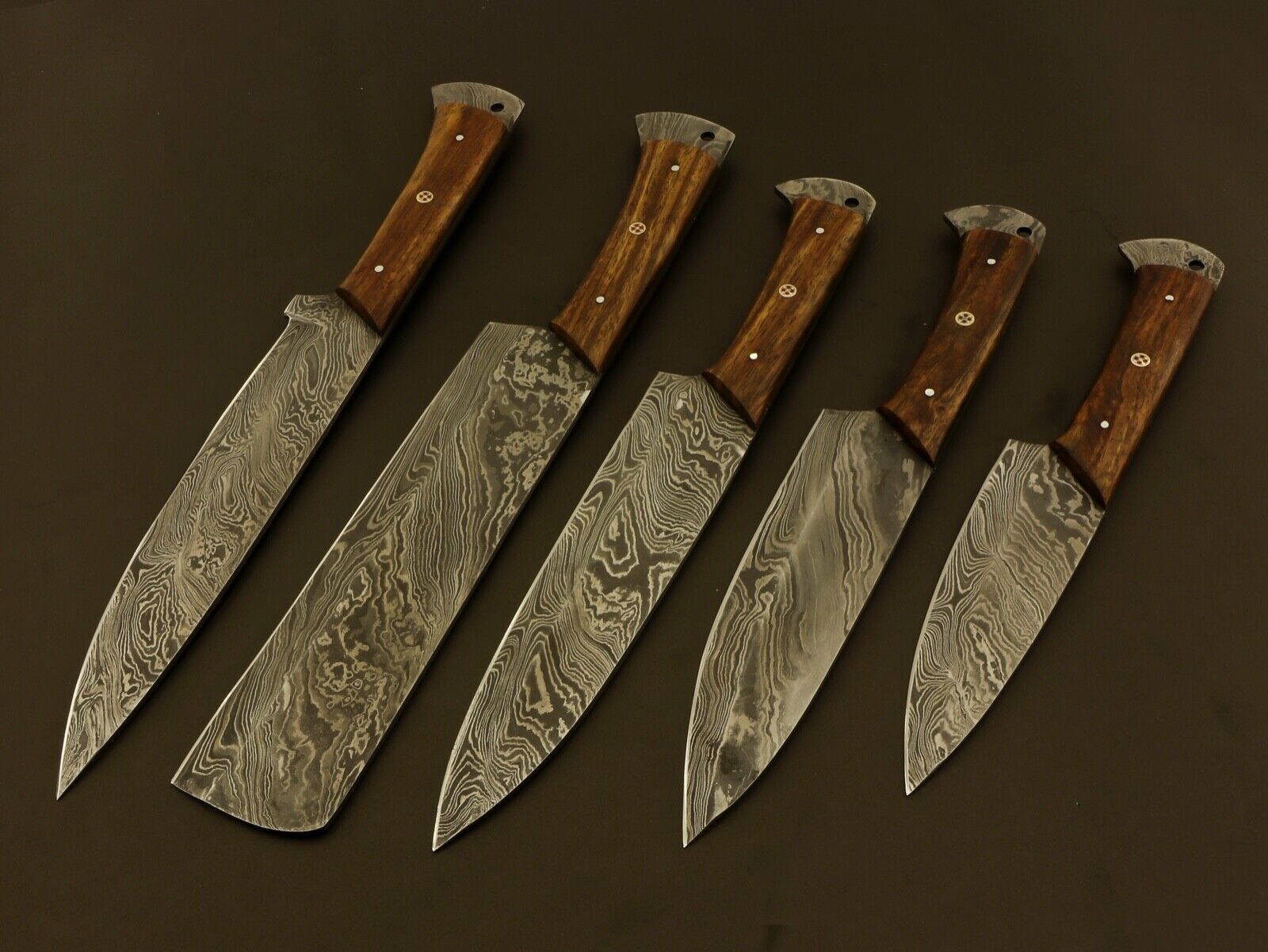 Collection of 5 handmade Damascus steel chef knives featuring wood handles and professional grade balance.