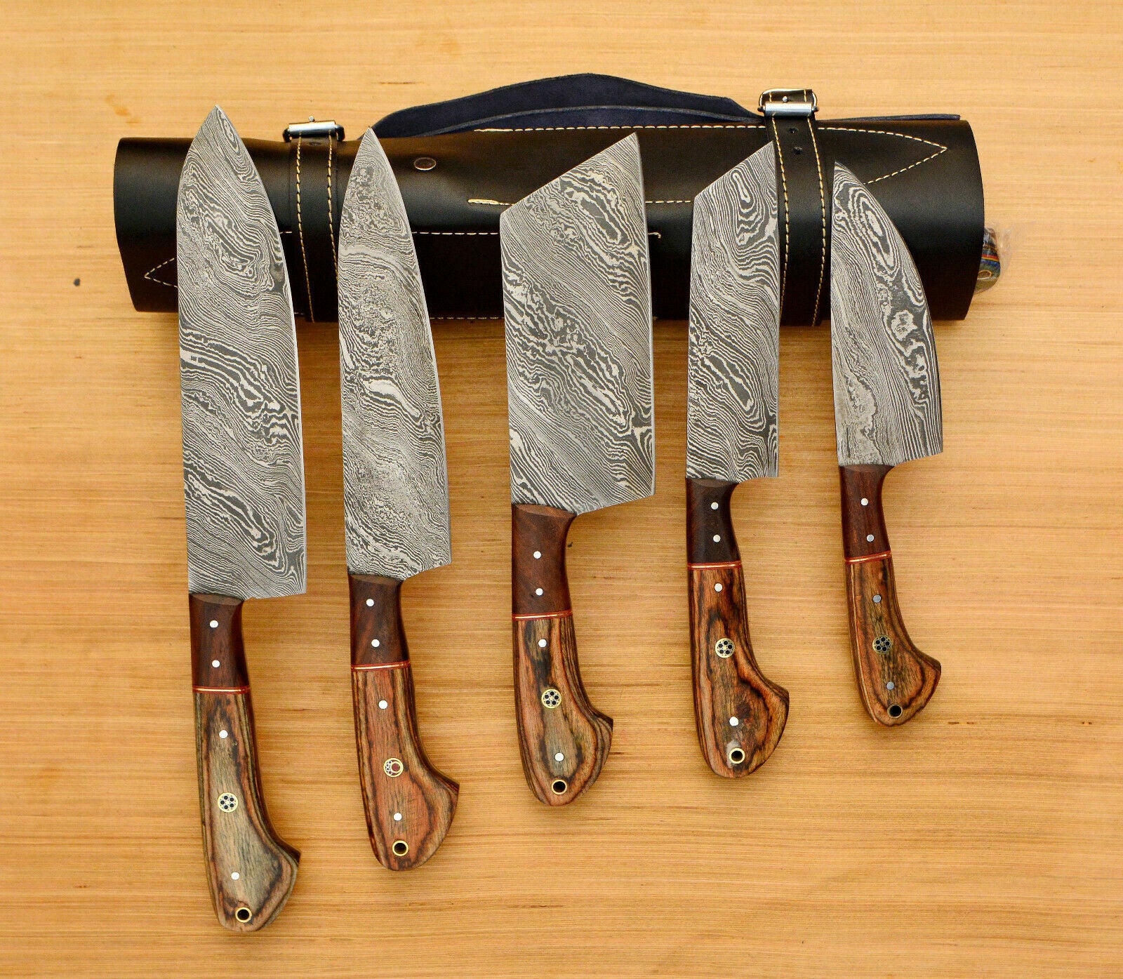 Handmade 5 pieces Damascus steel chef knife set neatly organized in a professional hand tooled leather roll.