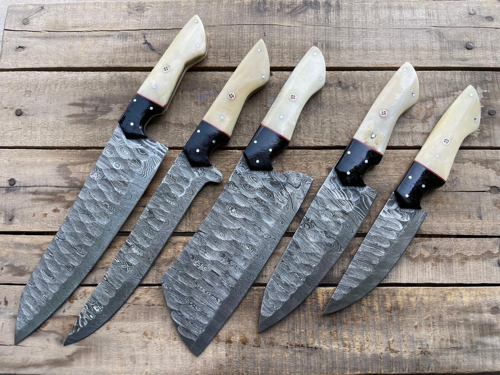 5 pieces custom handmade Damascus chef knife set with forged steel blades on a rustic wooden background.