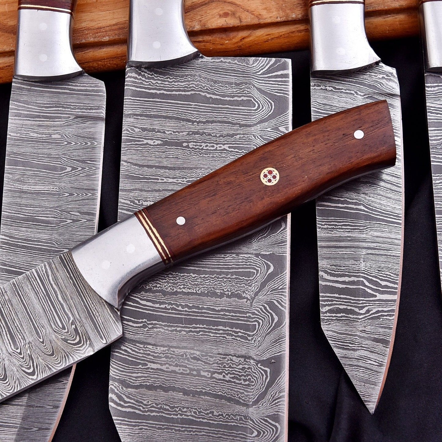 Close up of premium handcrafted knife handle showing intricate grain and texture on a Damascus steel kitchen chef knife.