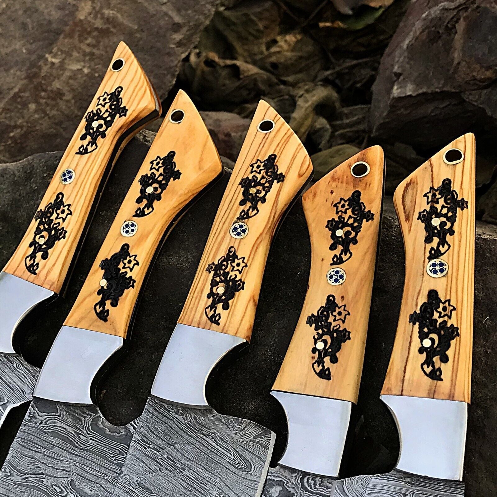 Detail shot of a custom handmade knife handle showing premium materials and expert craftsmanship for a Damascus chef knife set.