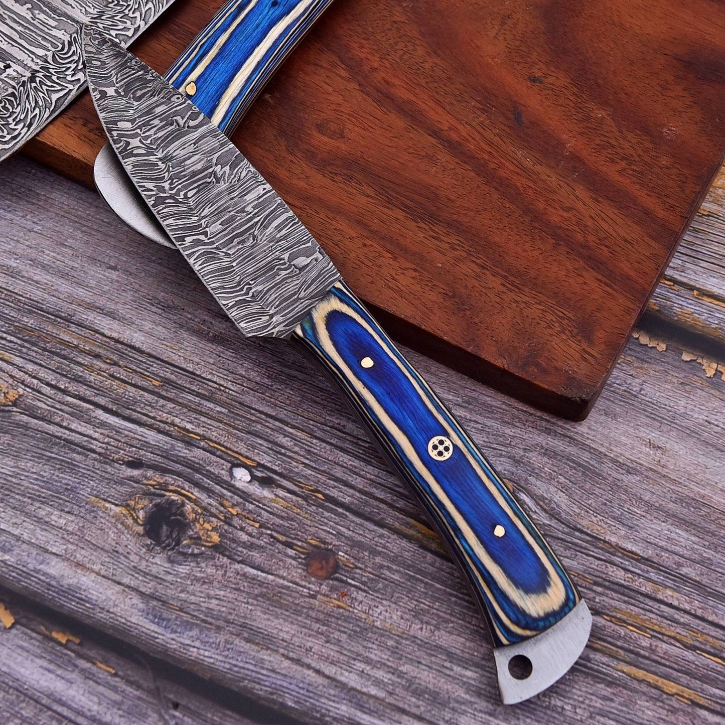 Close up of razor sharp Damascus steel blade pattern and professional grade file work on a handmade chef knife.