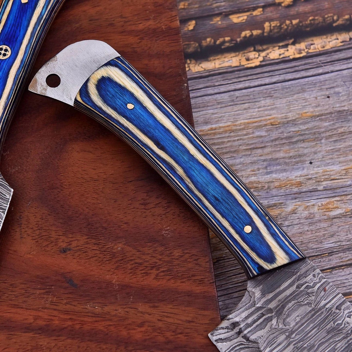 Detail view of intricate mosaic pin and engraved bone handle on a custom professional Damascus steel kitchen knife.