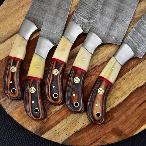 Detail view of premium bone and wood knife handles with steel bolsters on a hand forged Damascus steel set.