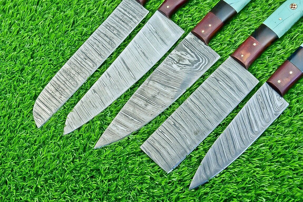 Close up of a hand forged Damascus steel chef knife blade showing unique layered patterns and a sharp satin finish.