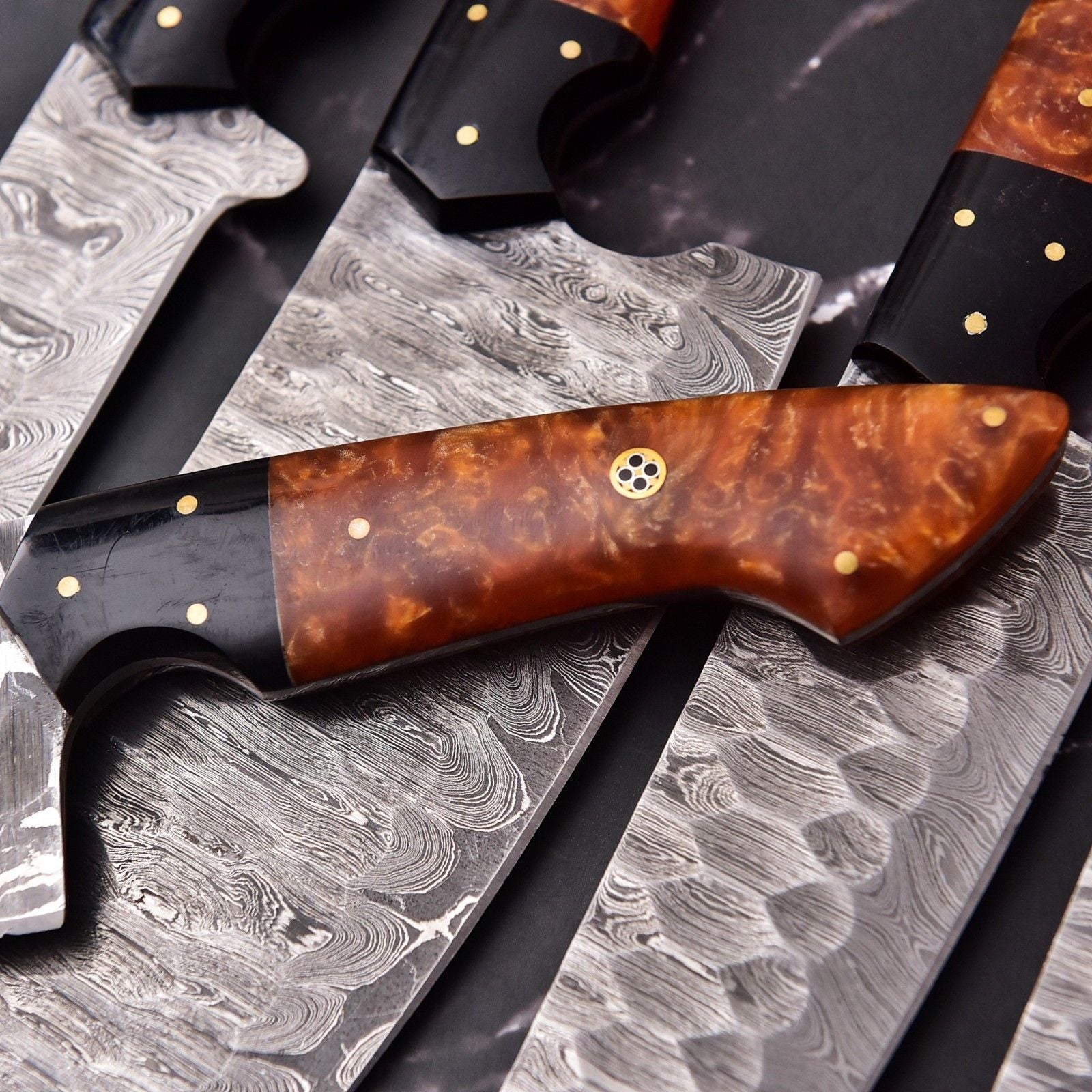 Detail view of ergonomic resin knife handle with Damascus steel bolster.