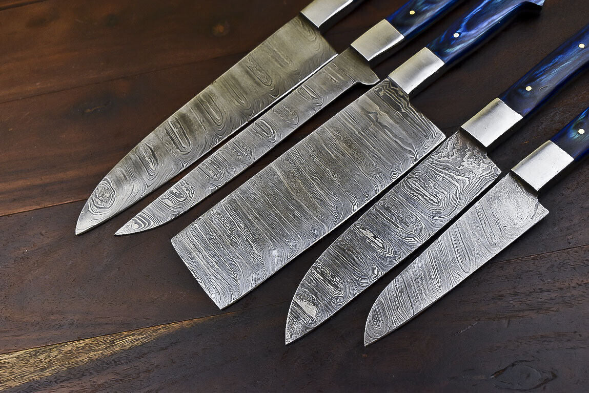 Hand forged Damascus steel chef knife blade showing unique layered patterns and sharp edge detail.