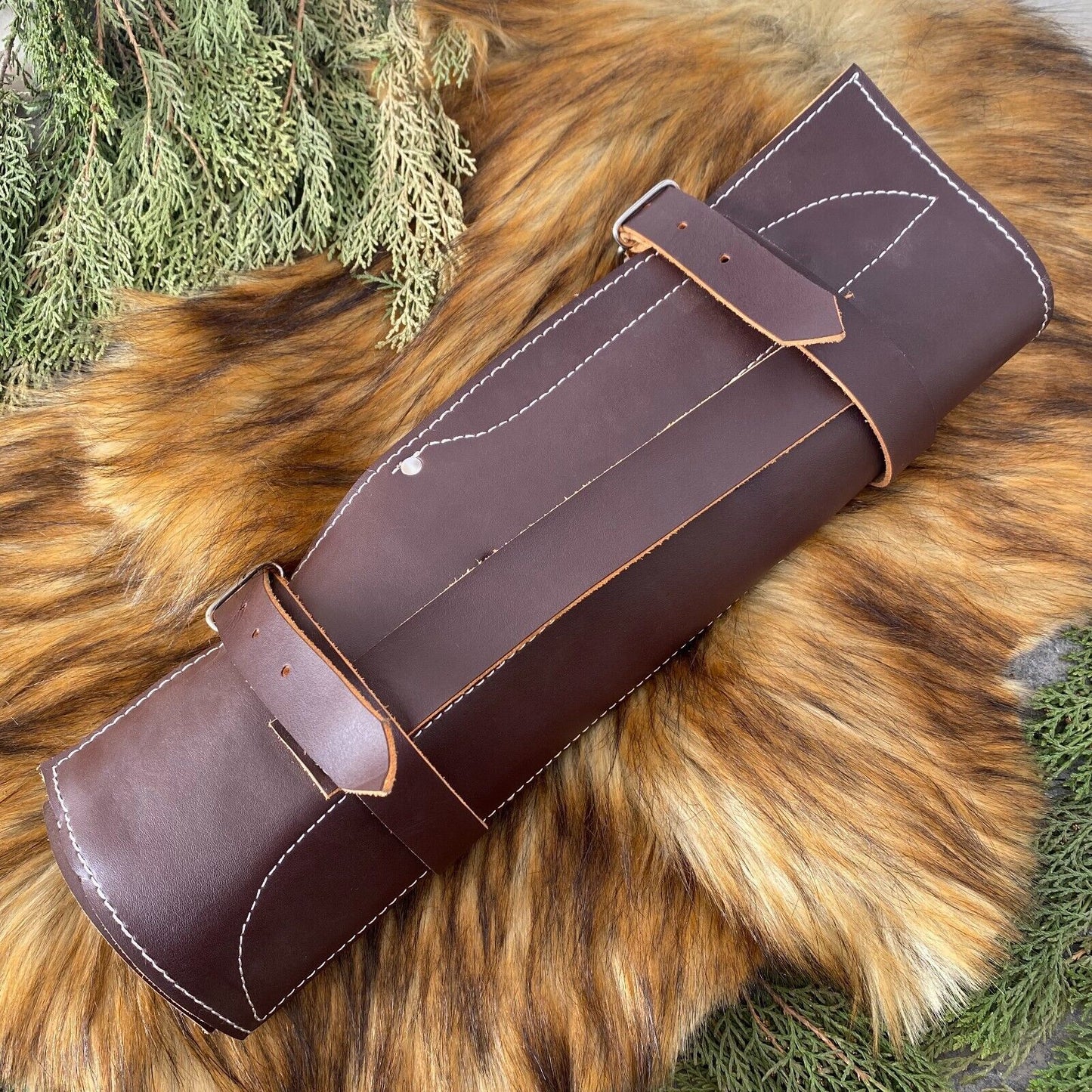 Professional custom chef knife set organized in a premium leather storage roll for culinary travel and protection.