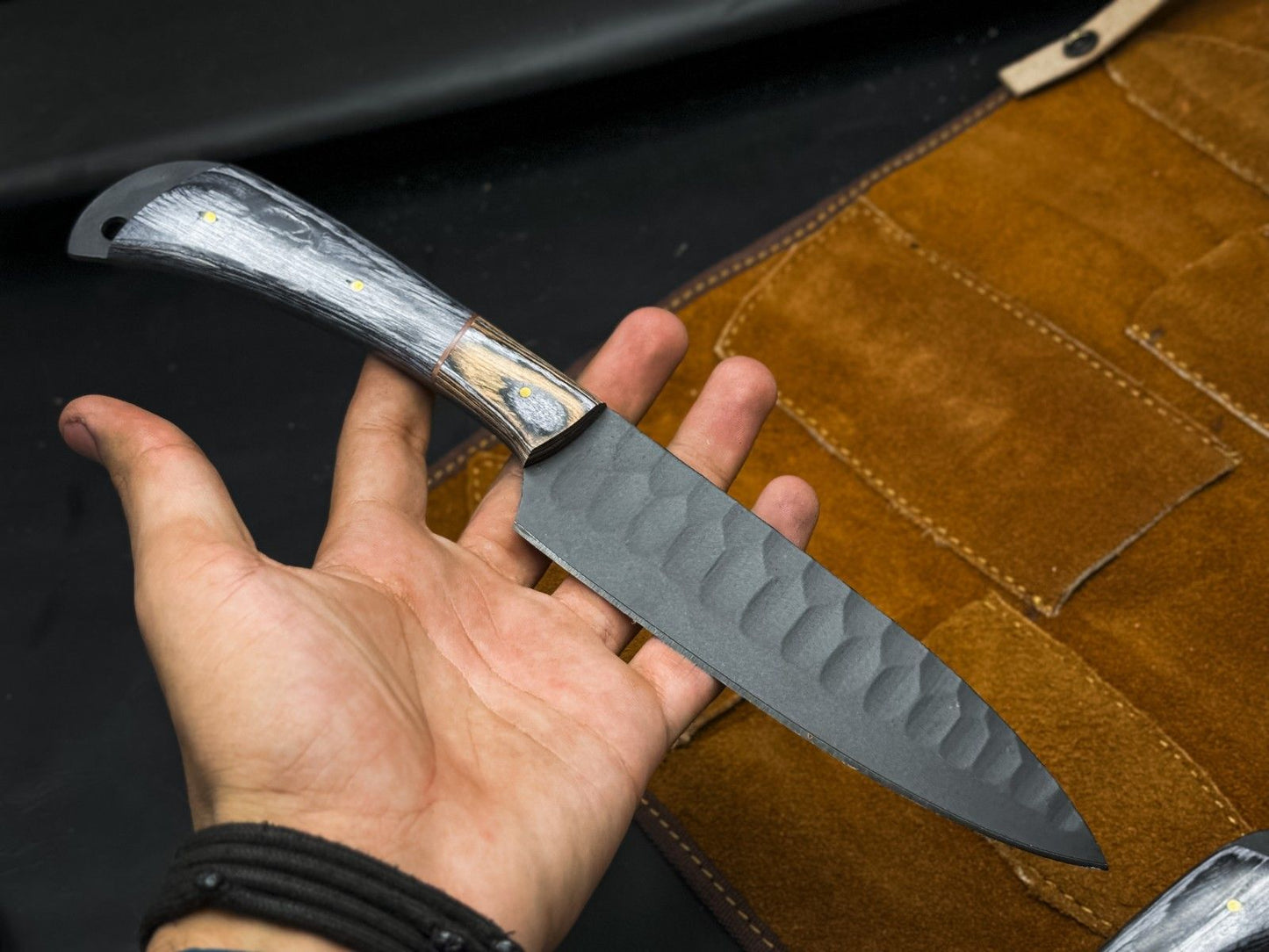 Close up of a rugged gray carbon steel drop point blade with a clean, plain edge finish.