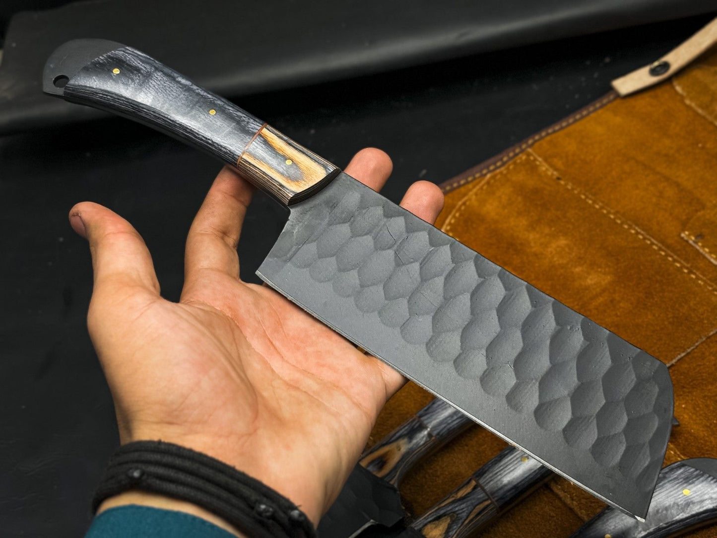 Close up of a rugged gray carbon steel drop point blade with a clean, plain edge finish.