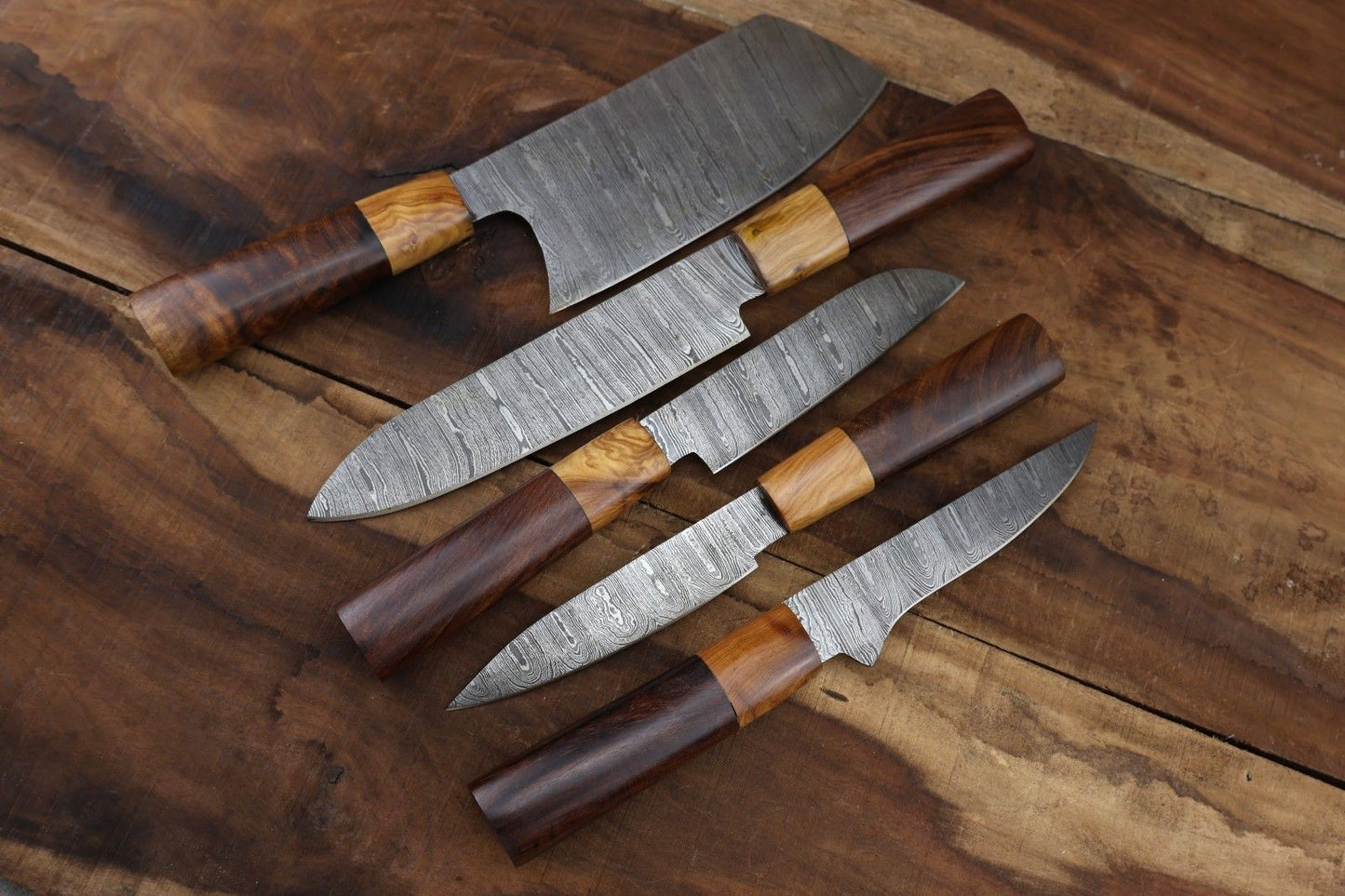 Detail view of unique natural olive wood grain handle on a custom hand forged Damascus steel kitchen and hunting knife.