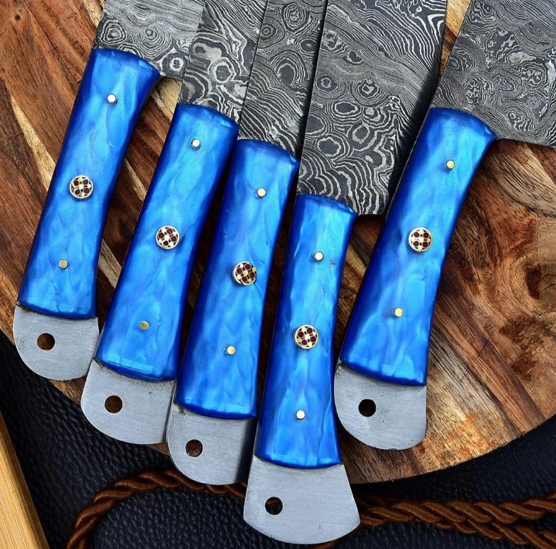 Detailed close up of custom blue resin handle scales on a hand forged 512 layer Damascus steel kitchen knife.