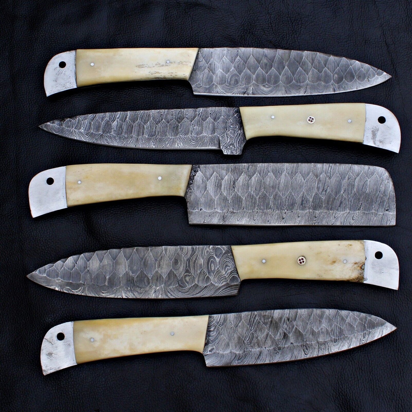 Detail view of full tang construction on a custom Damascus steel kitchen knife set.