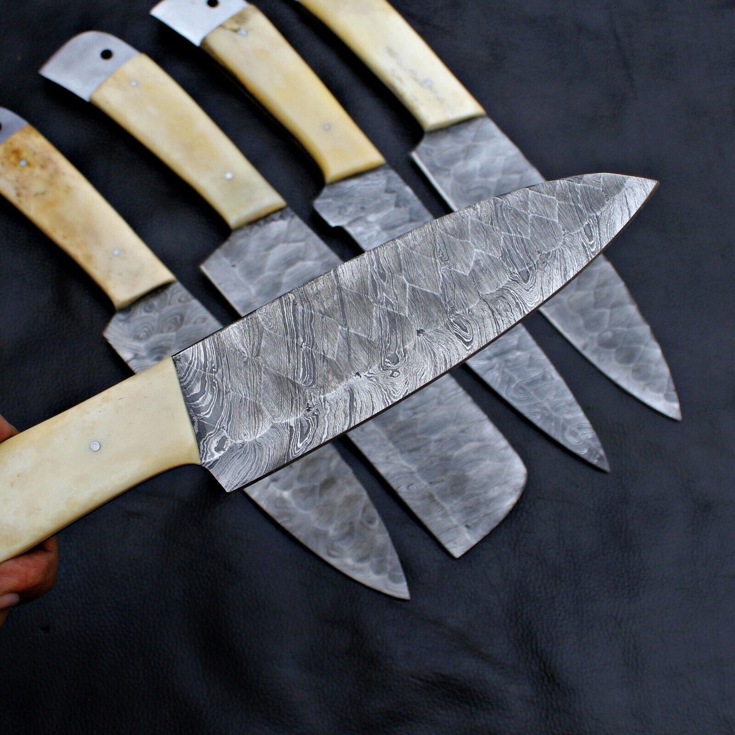 Close up of unique, hand forged Damascus steel pattern on a professional chef knife blade.