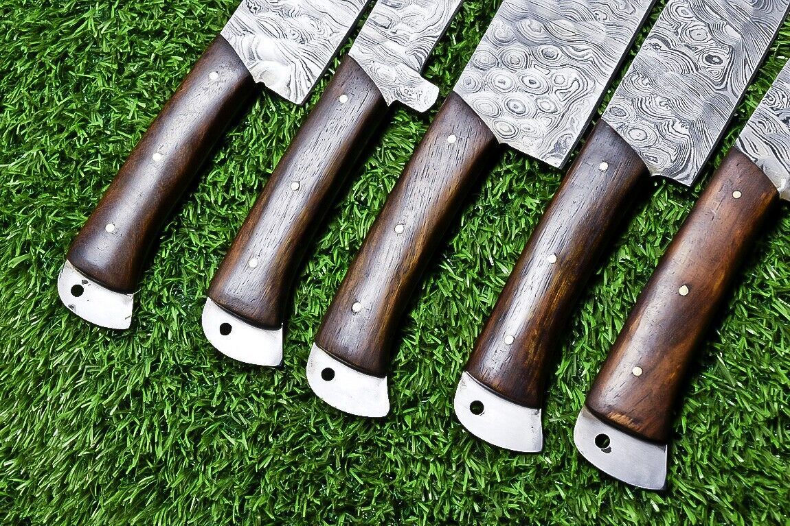 Side profile of a custom Damascus chef knife highlighting the ergonomic wooden handle grip and balanced blade shape.