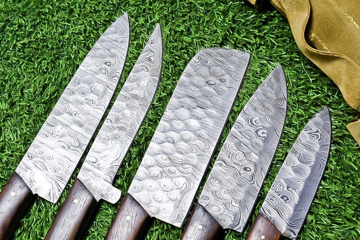 Close up of a sharp Damascus steel chef knife blade showing the distinct 384 layer pattern and satin finish.