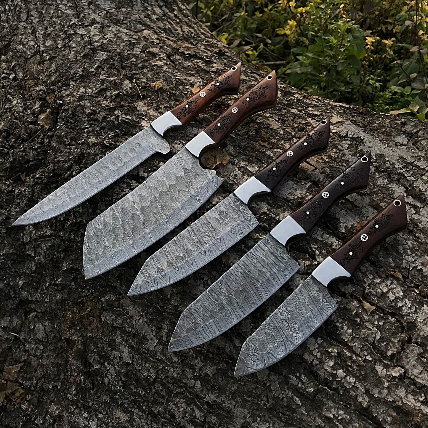 5 Pieces custom handmade Damascus chef knife set featuring forged steel blades and ergonomic handles arranged for display.