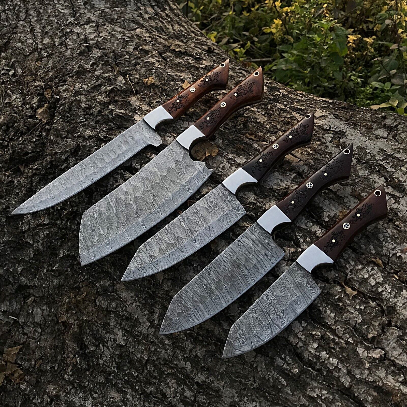 5 Pieces custom handmade Damascus chef knife set featuring forged steel blades and ergonomic handles arranged for display.