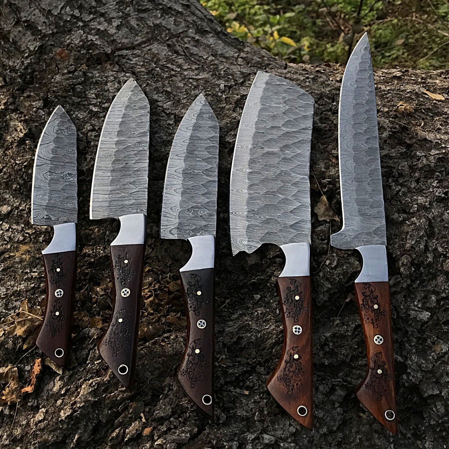 5 Pieces custom handmade Damascus chef knife set featuring forged steel blades and ergonomic handles arranged for display.
