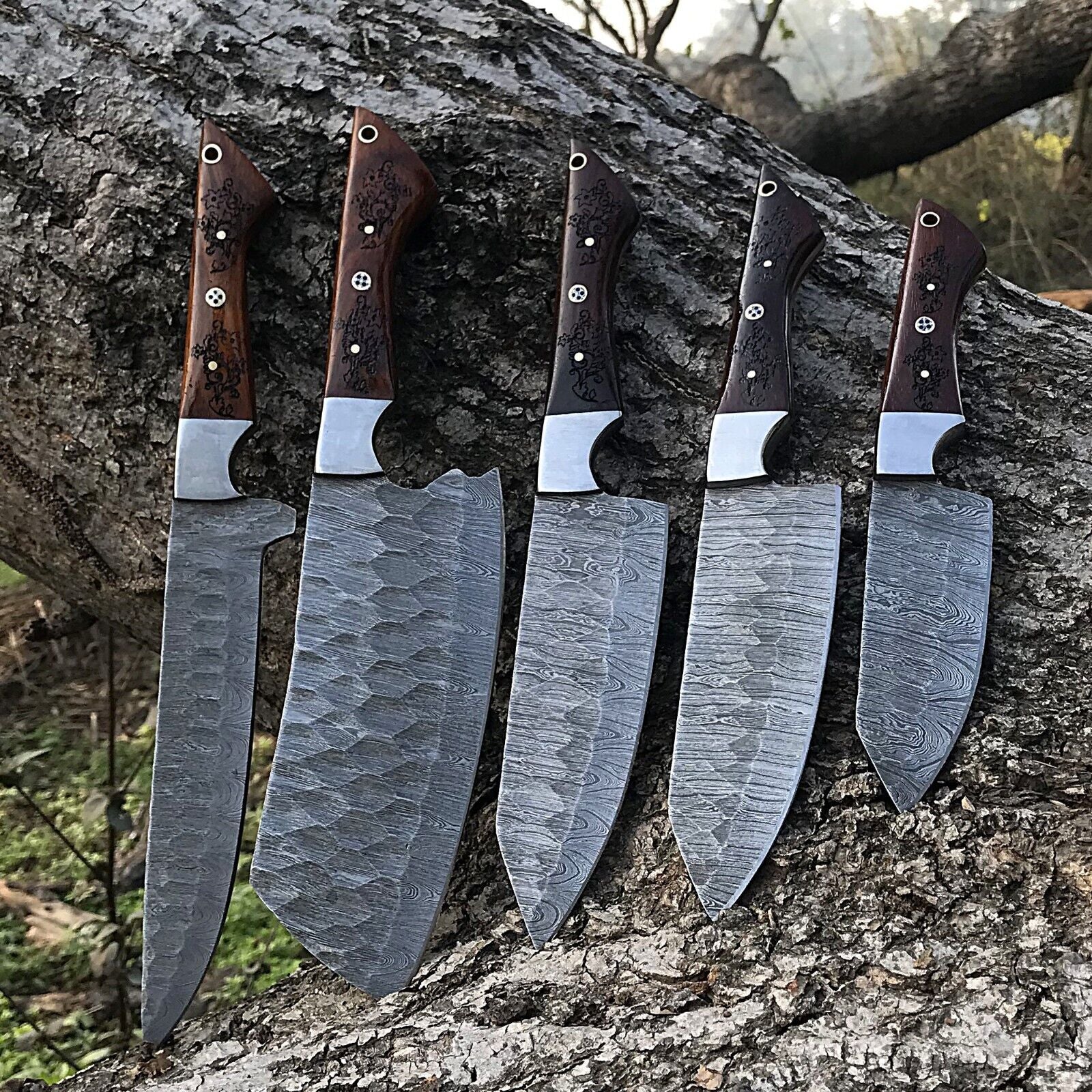 5 Pieces custom handmade Damascus chef knife set featuring forged steel blades and ergonomic handles arranged for display.
