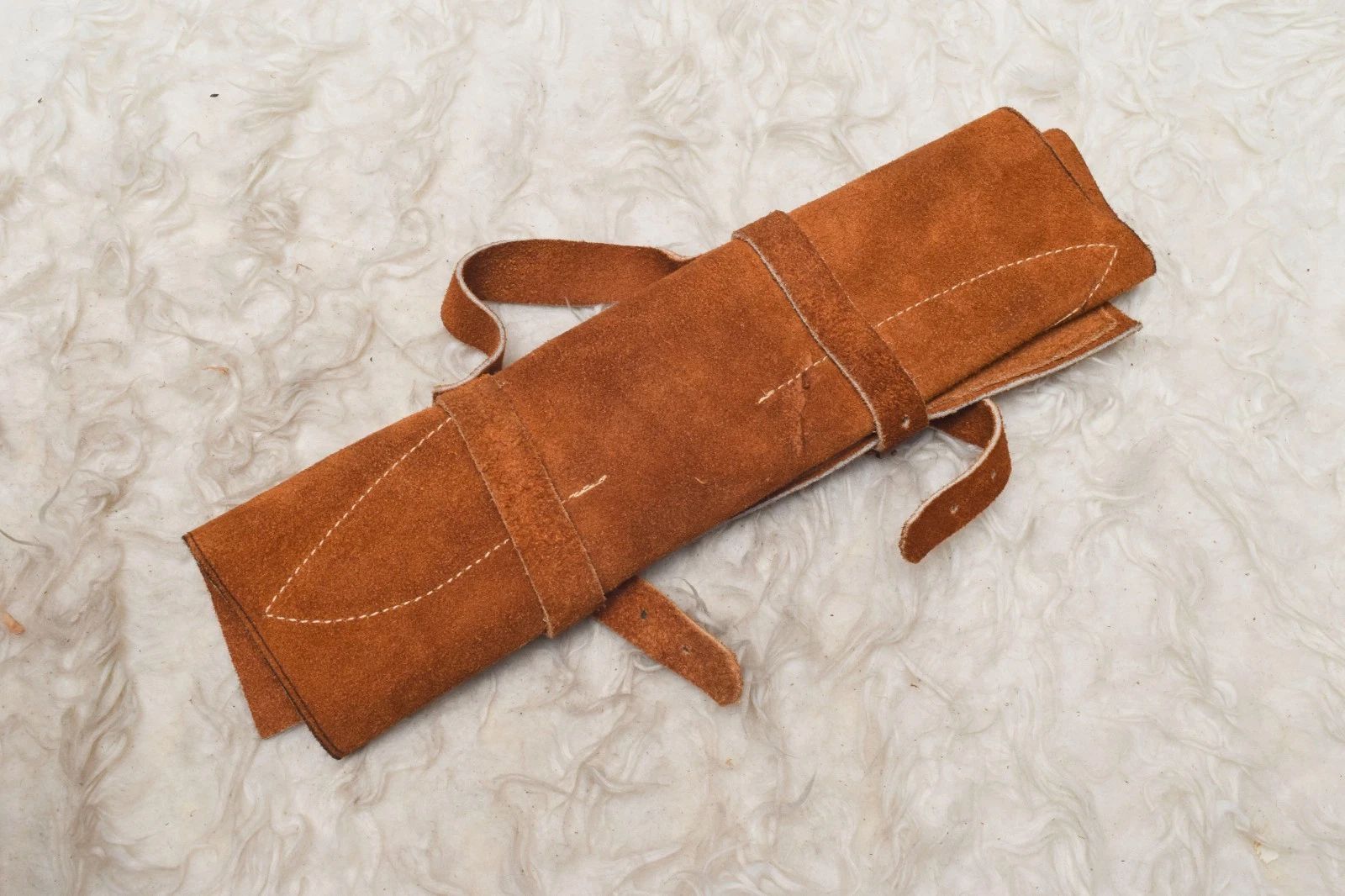 Hand stitched leather roll containing a 5 pieces handmade Damascus steel chef knife set for professional kitchen and travel storage