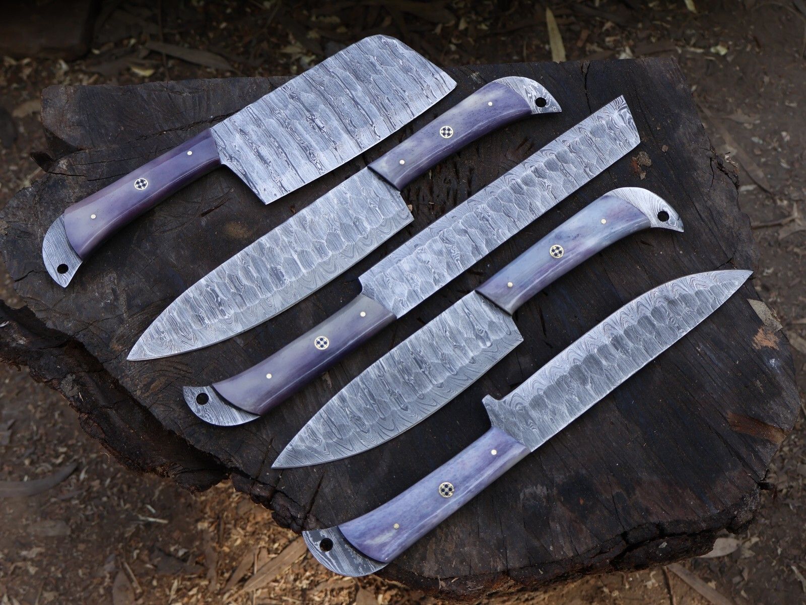 Detailed view of artisan bone handle scales with mosaic pin on a handmade Damascus chef knife.