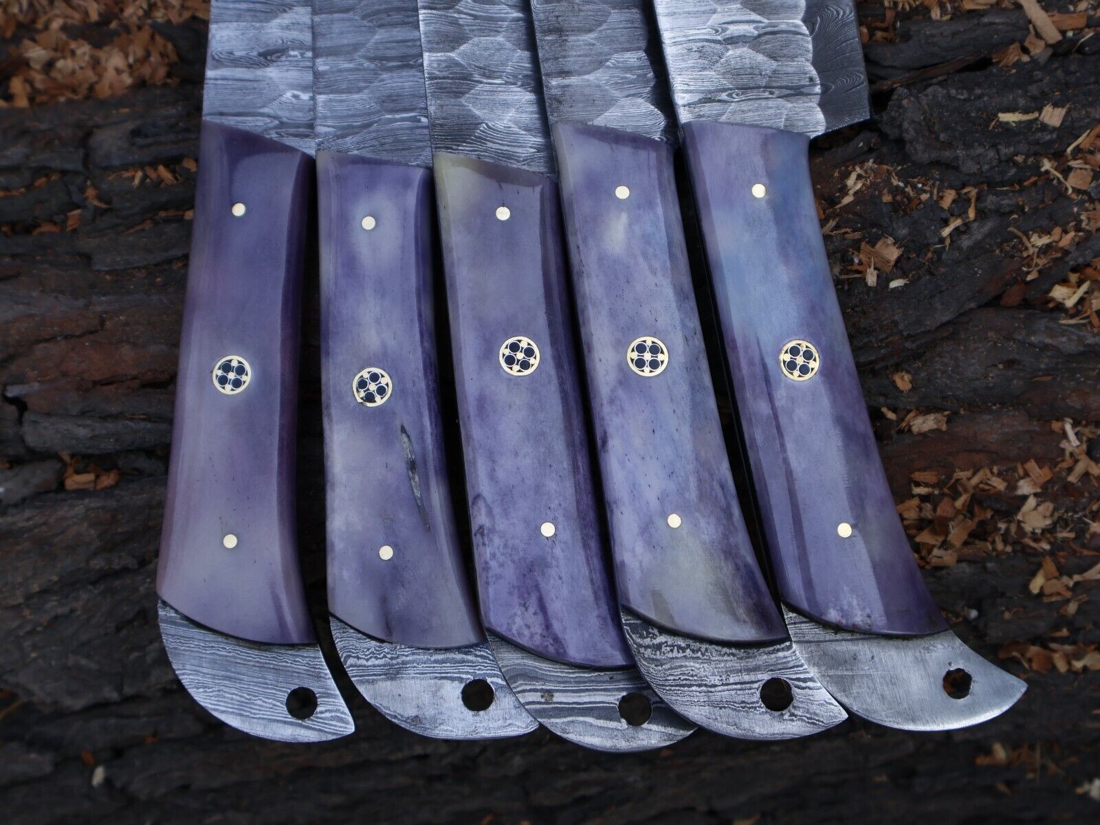 Detailed view of artisan bone handle scales with mosaic pin on a handmade Damascus chef knife.