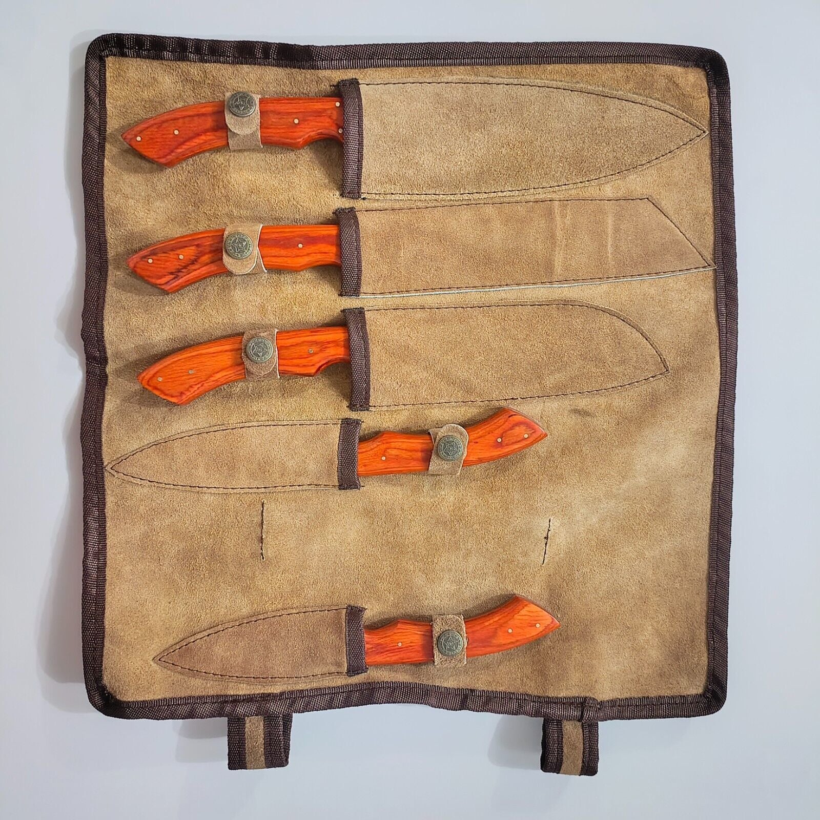 Detailed view of durable, hand stitched leather storage roll for Damascus kitchen knives, showing rugged texture and quality craftsmanship.