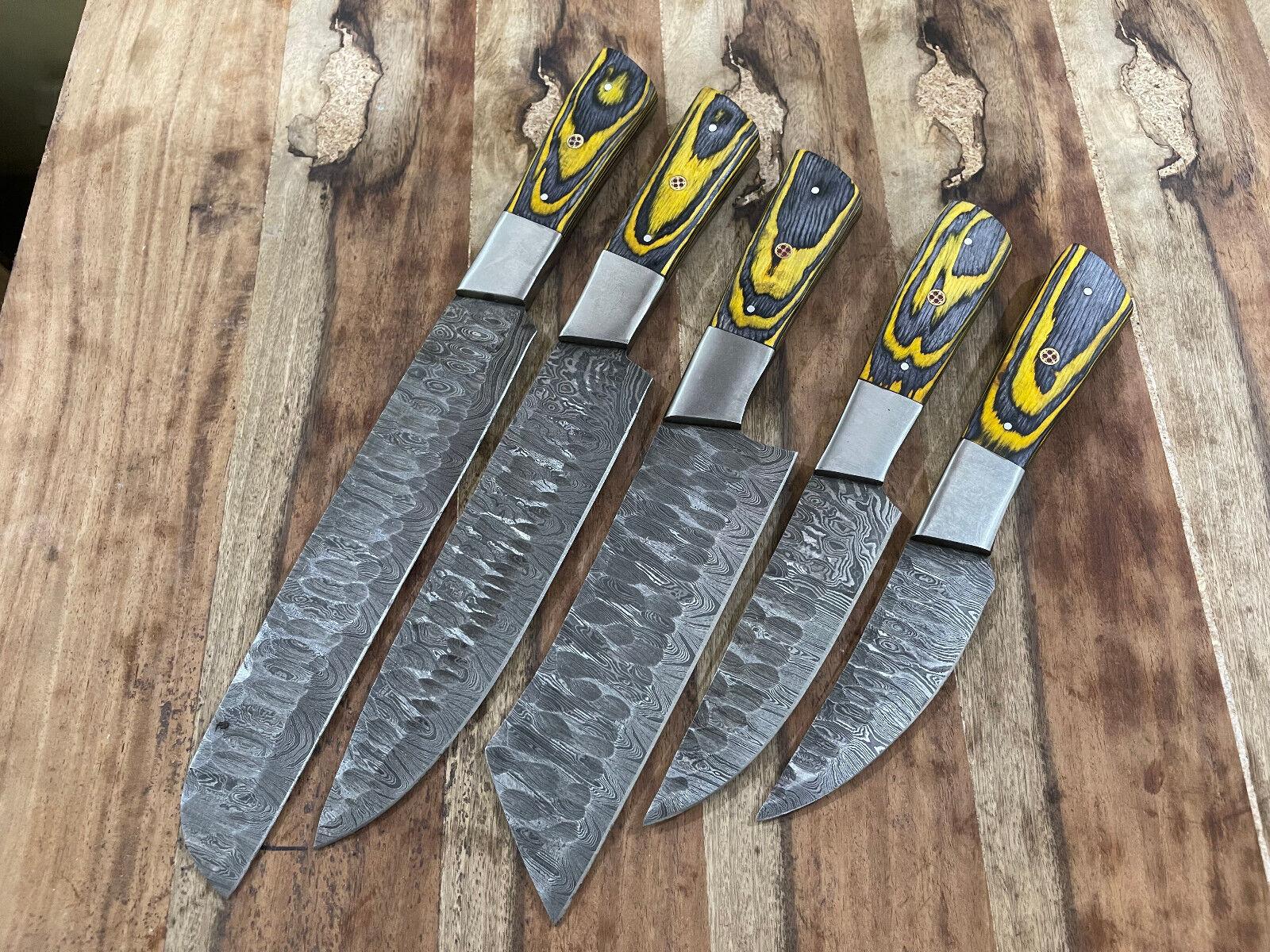 5 pieces custom handmade Damascus chef knife set arranged on a kitchen counter, showcasing unique patterned steel blades.