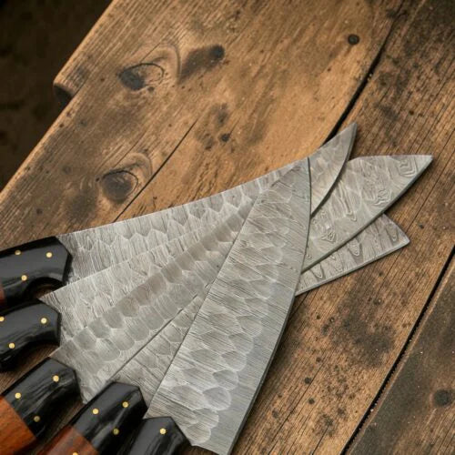 Overhead view of 5 pcs Damascus steel cooking knives fanned out on a wooden table