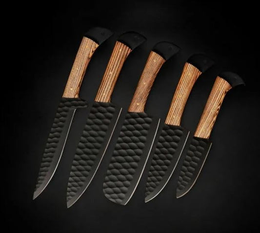 Five black kitchen knives with striped ashwood handles on a dark background