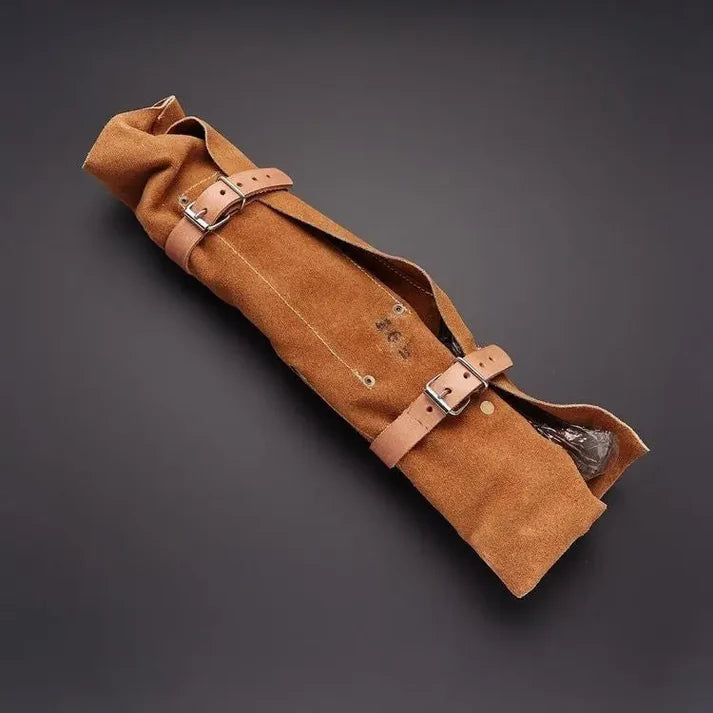 Tan suede knife roll rolled shut with two leather buckle straps