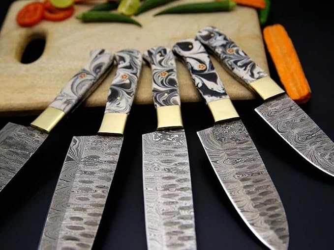 Close up of black and gray marbled acrylic handles with cream bolsters and orange flower pins