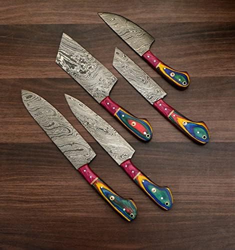 Damascus steel blades with rainbow acrylic handles arranged closely on a wood table