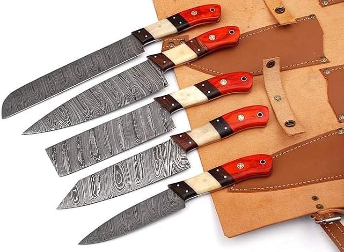 Damascus Steel Chef Knife Set of 5 with red wood, bone and dark wood handles, laid out beside a leather roll bag