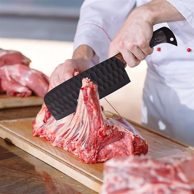 Hand using the Damascus steel cleaver from the 5 piece set to chop meat