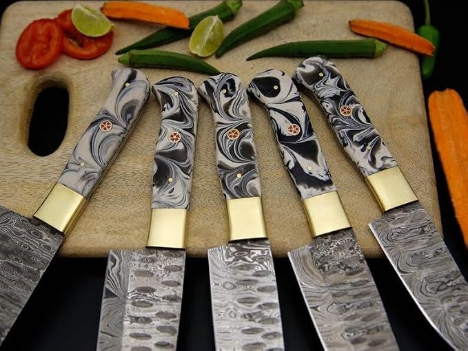 Close up of black and gray marbled acrylic handles with cream bolsters and orange flower pins