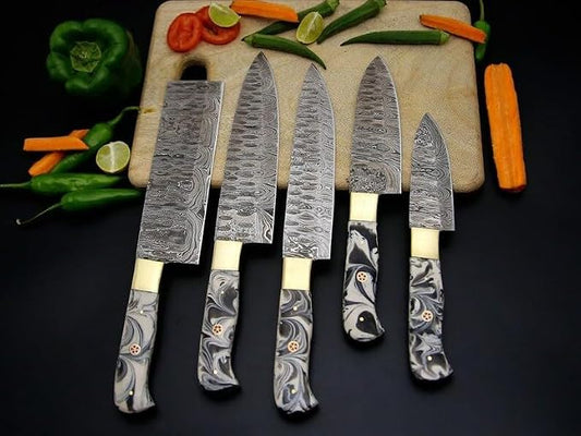 Damascus steel chef knives with marbled acrylic handles arranged on a cutting board with peppers and carrots