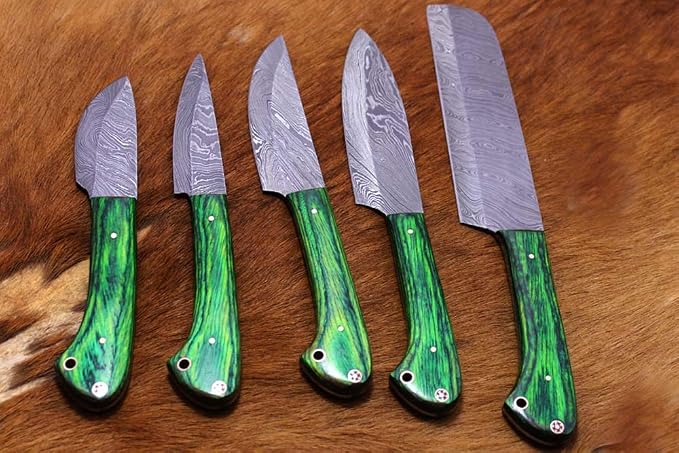5 piece Damascus steel knife set fanned out on fur showing hand forged wavy blade pattern