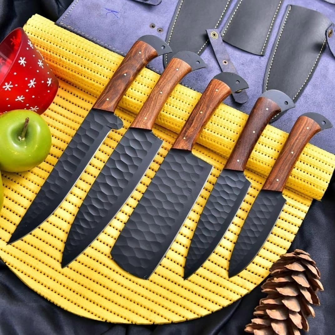 Five black hammered kitchen knives with rosewood handles arranged in an open black leather knife roll.