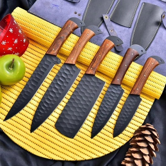 Five black hammered kitchen knives with rosewood handles arranged in an open black leather knife roll.