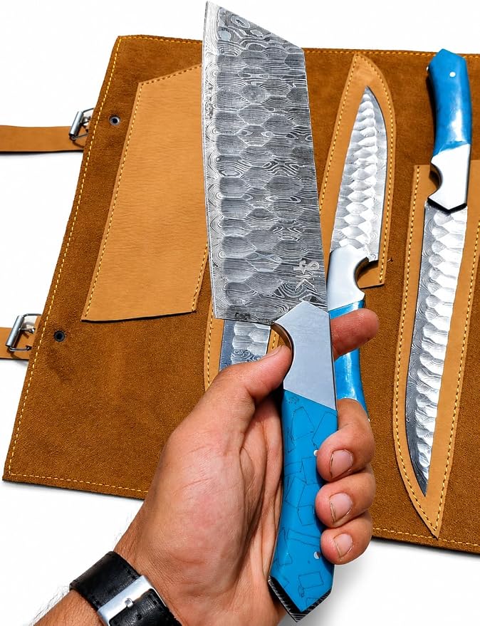 Hand holding Damascus steel chef knife with blue acrylic handle and hammered blade